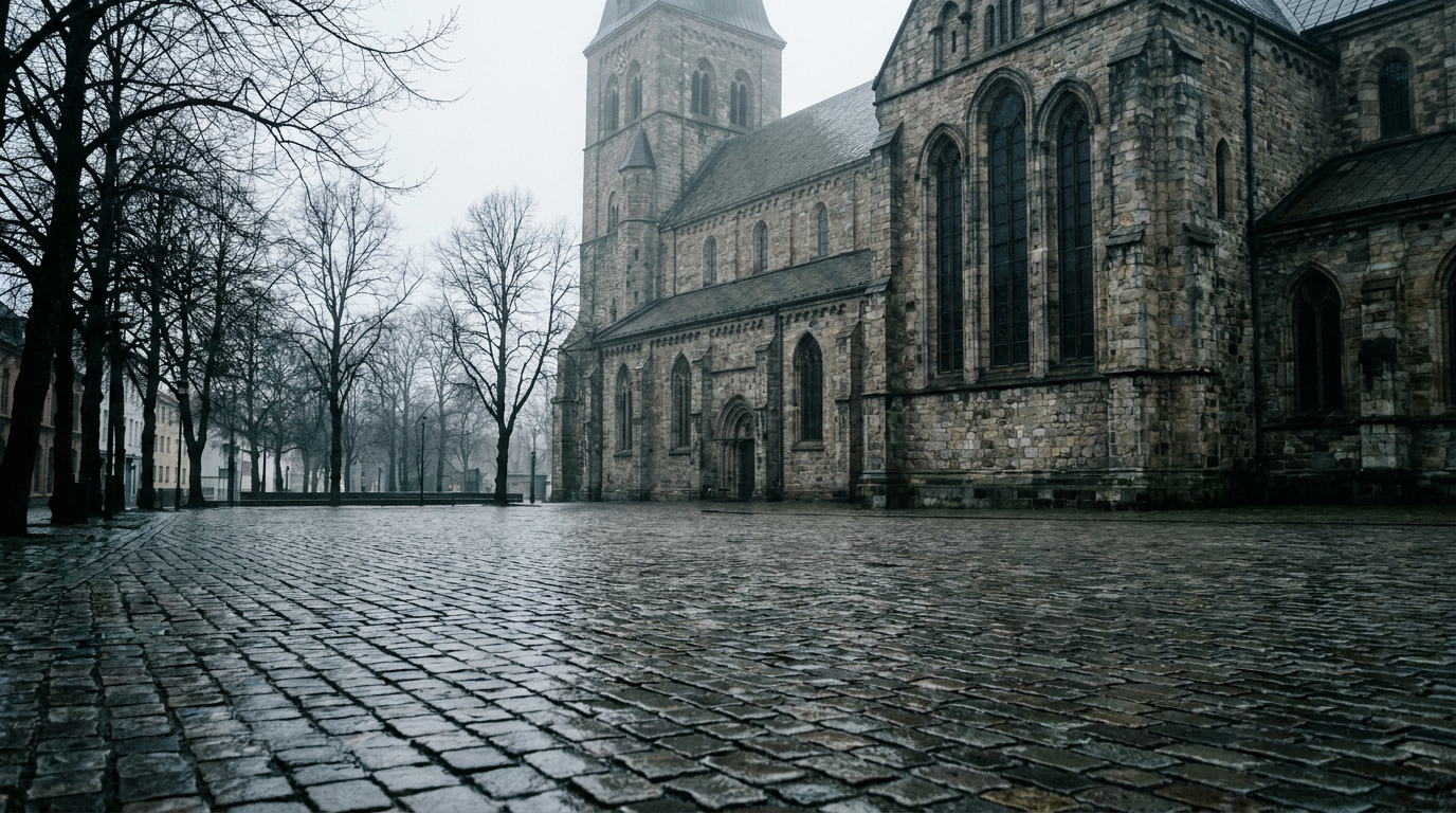 Stone cathedral beside an empty wet cobbled square in Norway on an overcast morning