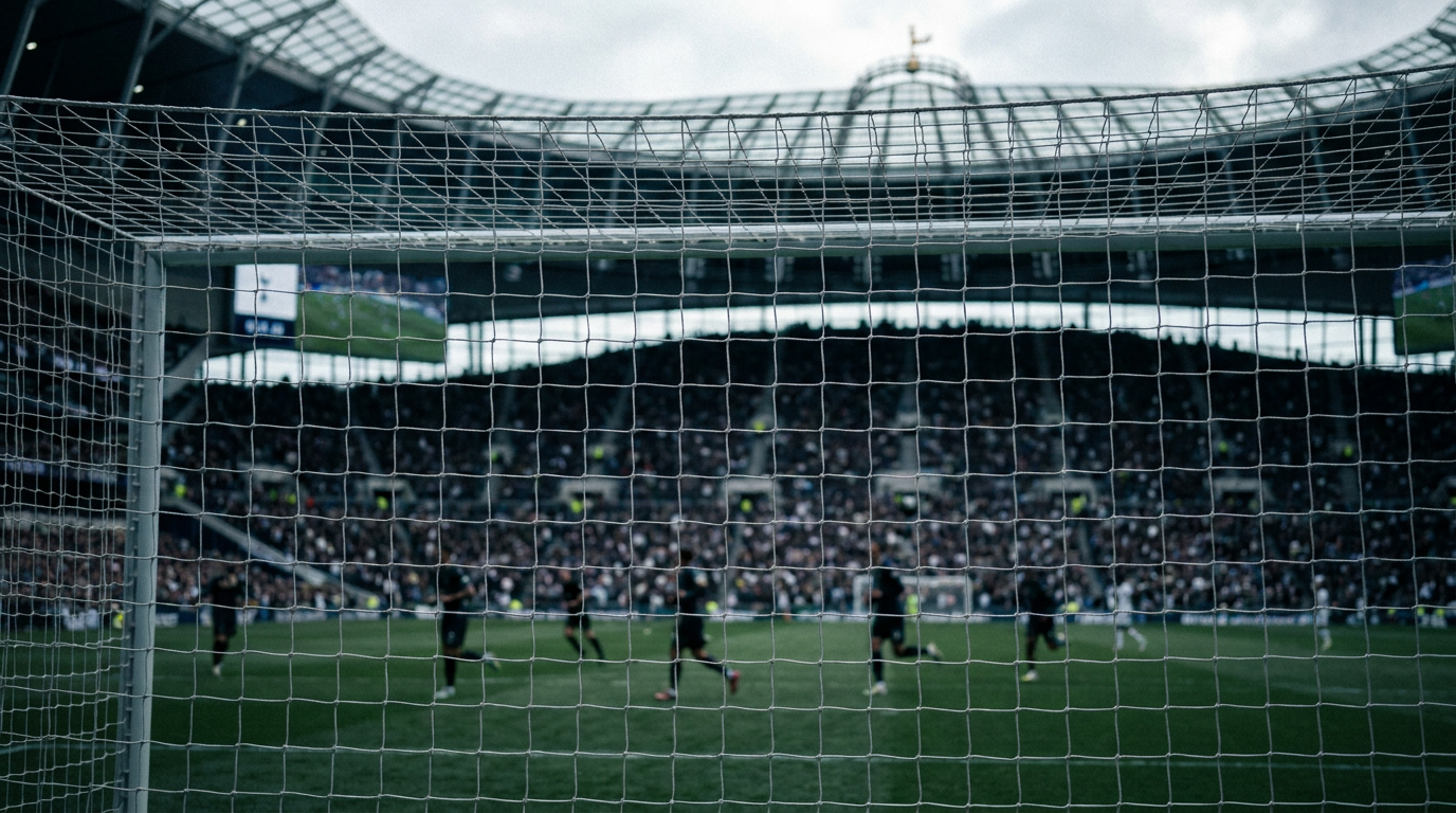 View across the pitch from behind a goal at Tottenham’s home ground, with players and spectators in the distance.